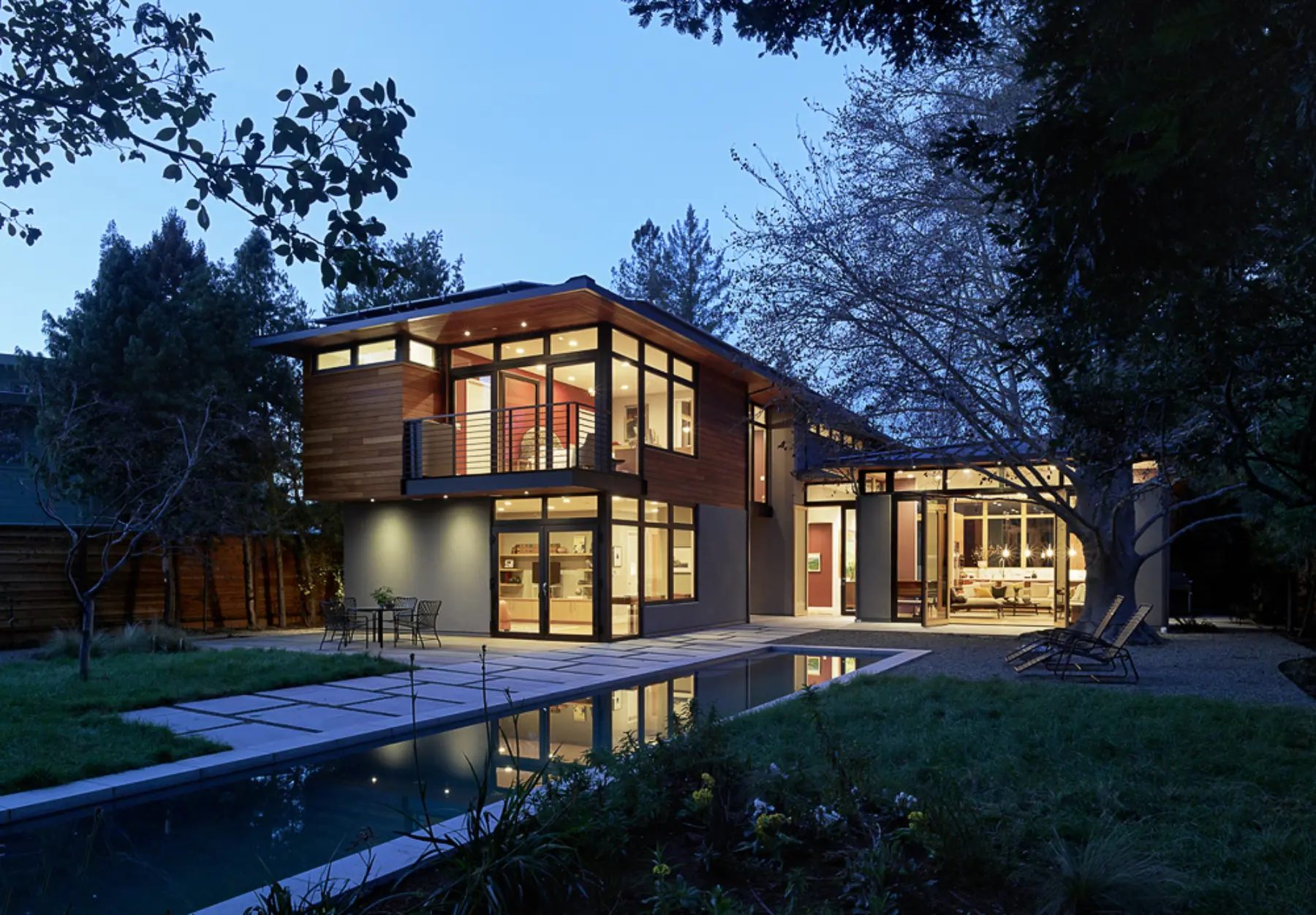 Back exterior of modern menlo park home glowing at dusk