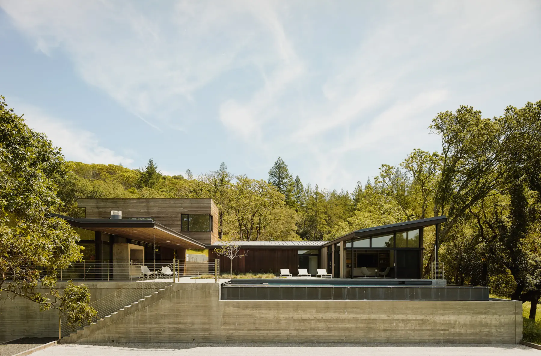 Modern retreat home situated on concrete platform, secluded in nature